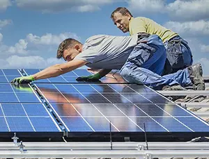 2 men installing a solar panel array on a home roof.