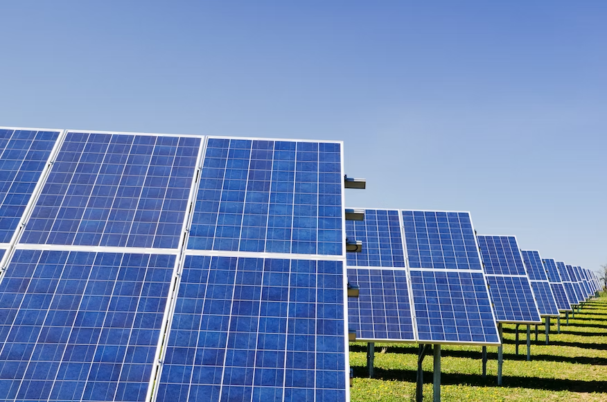 A solar field on green grass generating electricity for a community solar project.