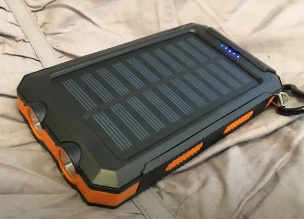 Oukafen Solar Charger on bed with carabiner clip
