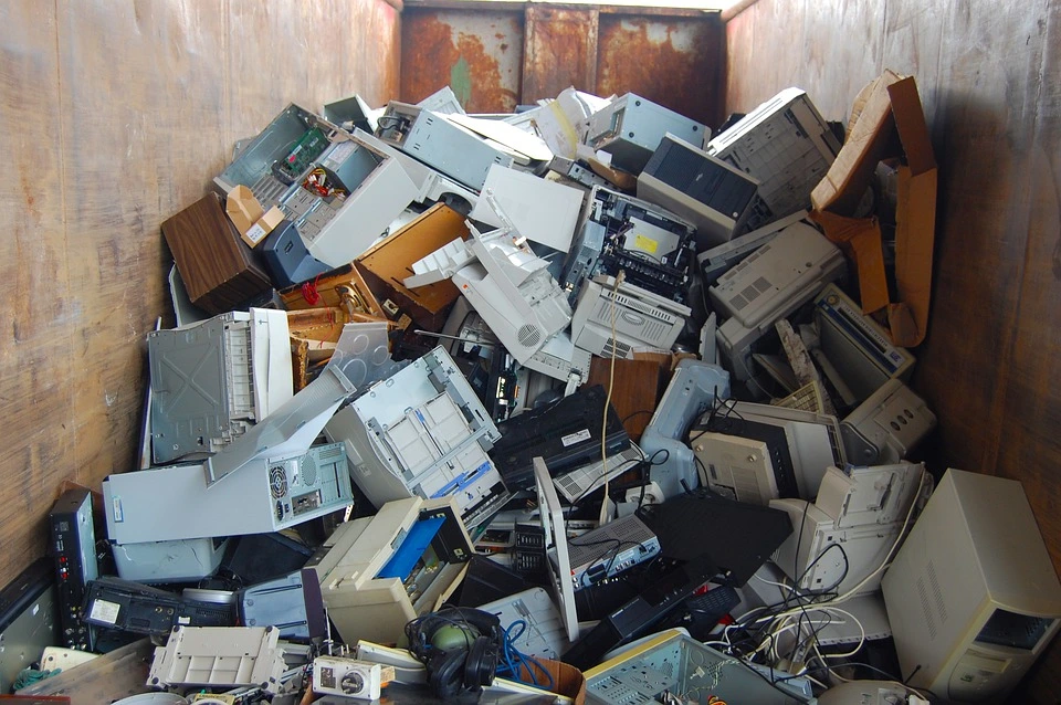 A bin of old computers, monitors, printers, fax machines, stereo equipment, and mice that are ready for recycling.