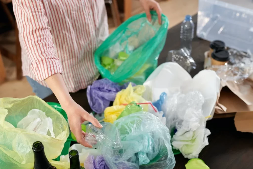 A woman sorting her recyclables and garbage so she can help avoid causing environmental problems
