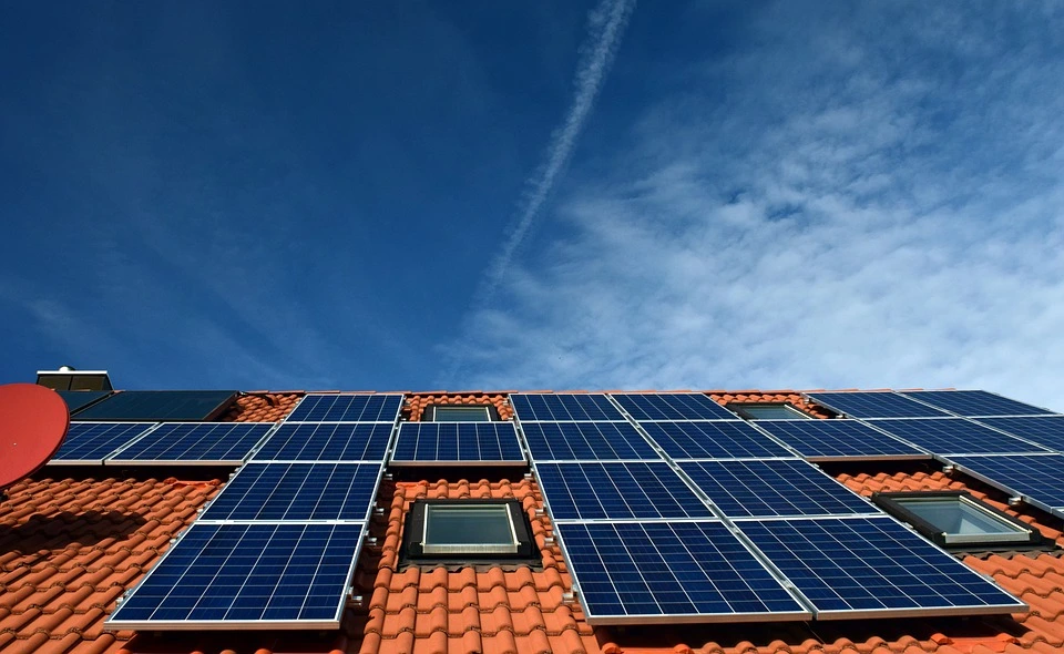 Solar panels on a red tile roof with skylights provide all the energy this home needs.