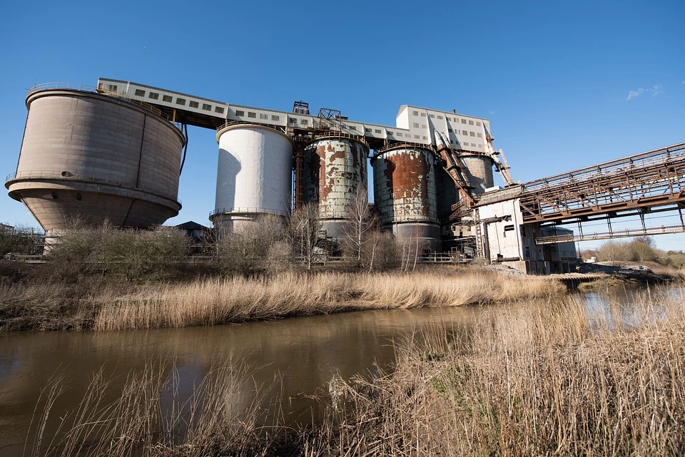 A polluted waterway with an abandoned chemical plant on the shore